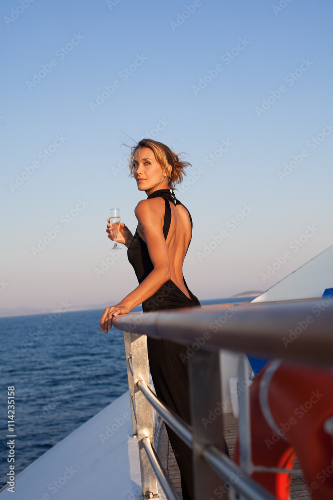 femme sur le pont d'un bateau avec une coupe de champagne Stock Photo |  Adobe Stock