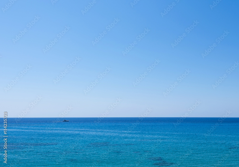 Photo of sea in protaras, cyprus island with a boat at horizon.