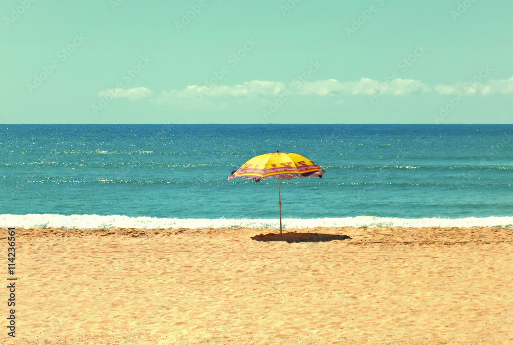 White sandy beach, sea and blue sky with umbrella 