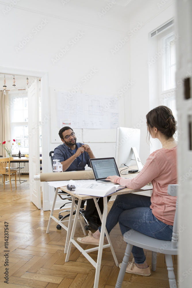 Two creative professionals working in office