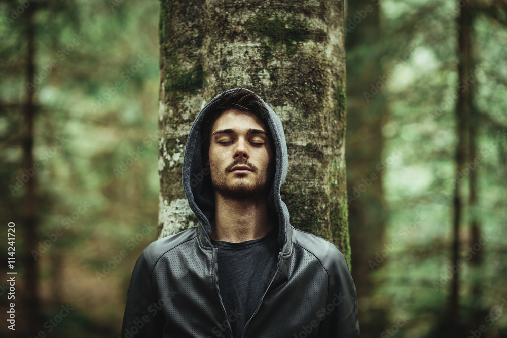 Man leaning on a tree with eyes closed Man leaning on a tree with eyes closed