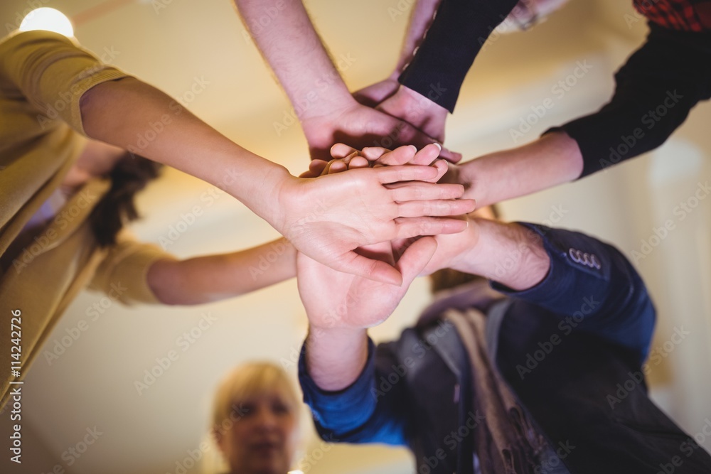 Creative business people stacking hands in office Creative business people stacking hands in office
