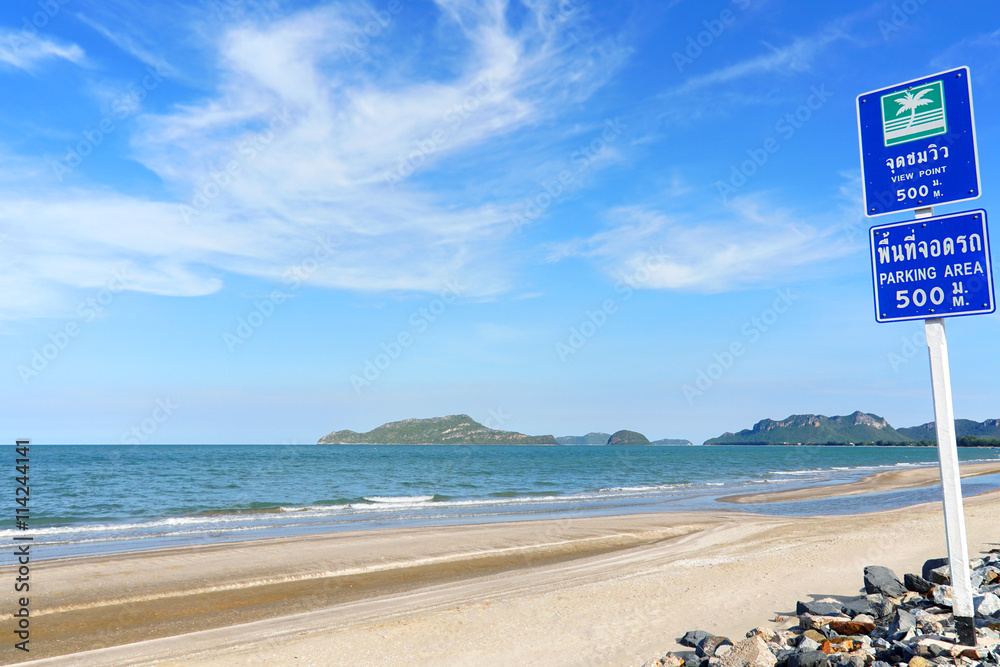 Naklejka premium Coastal asphalt road with the bicycle lane and cloudy blue sky at Hua Hin, Southern Thailand.
