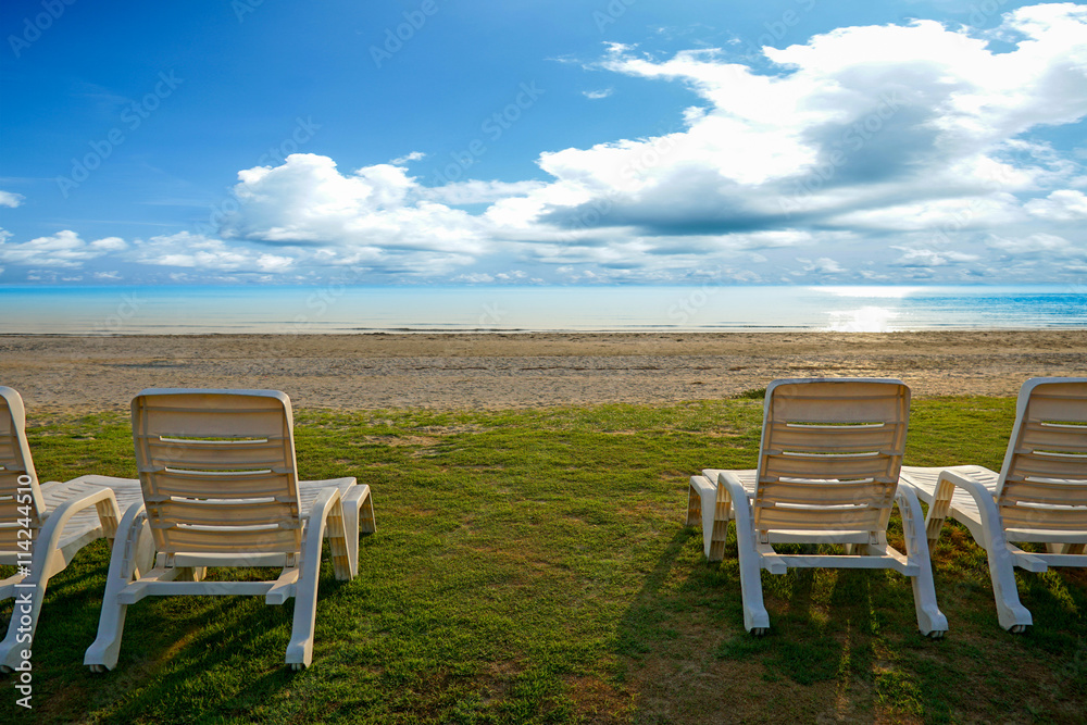 Fototapeta premium Beach chairs and blue sky at the tropical beach. Pranburi, Thailand.