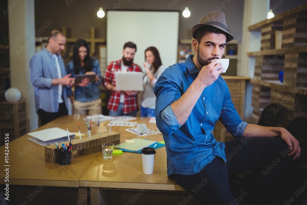 Stylish businessman drinking coffee while sitting at table Stylish businessman drinking coffee while sitting at table