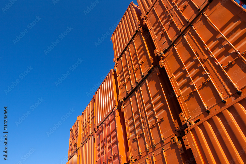 Fototapeta premium Stacks of orange shipping containers