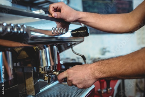 Close-up of barista using espresso machine at coffee house