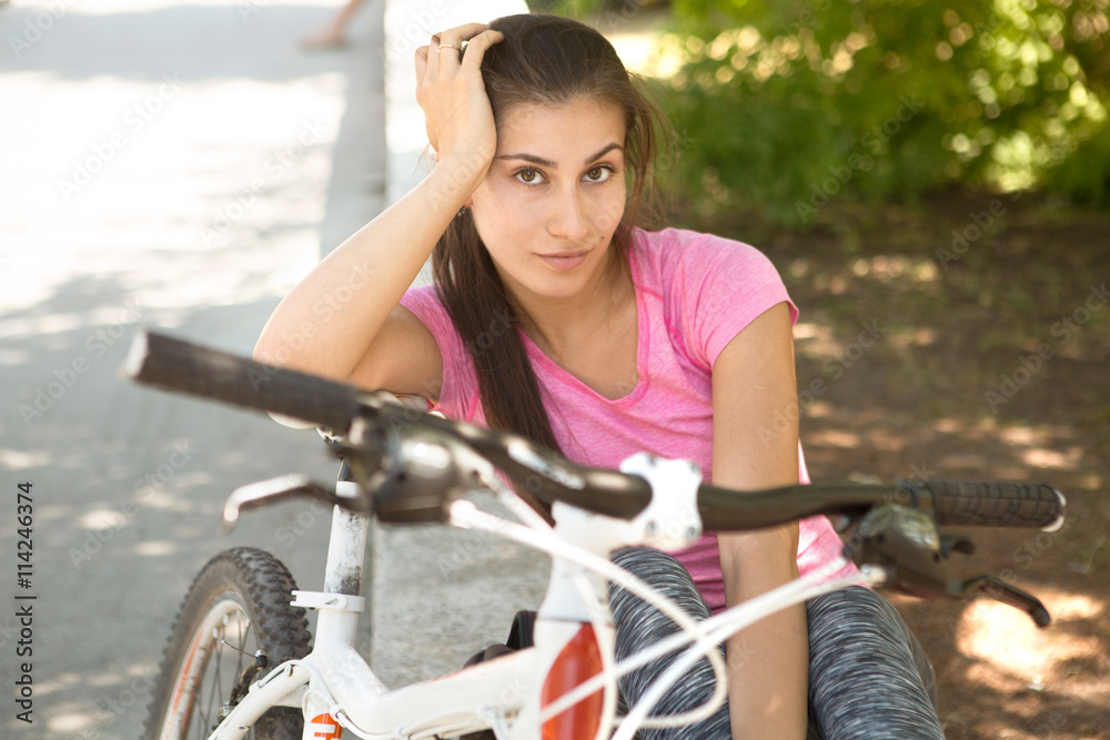 Obraz premium Beautiful young woman with bike in the city