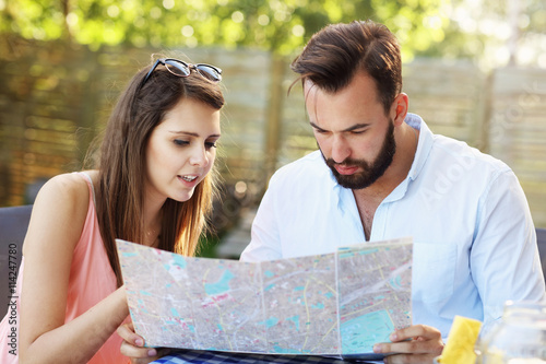 Young couple with map in cafe