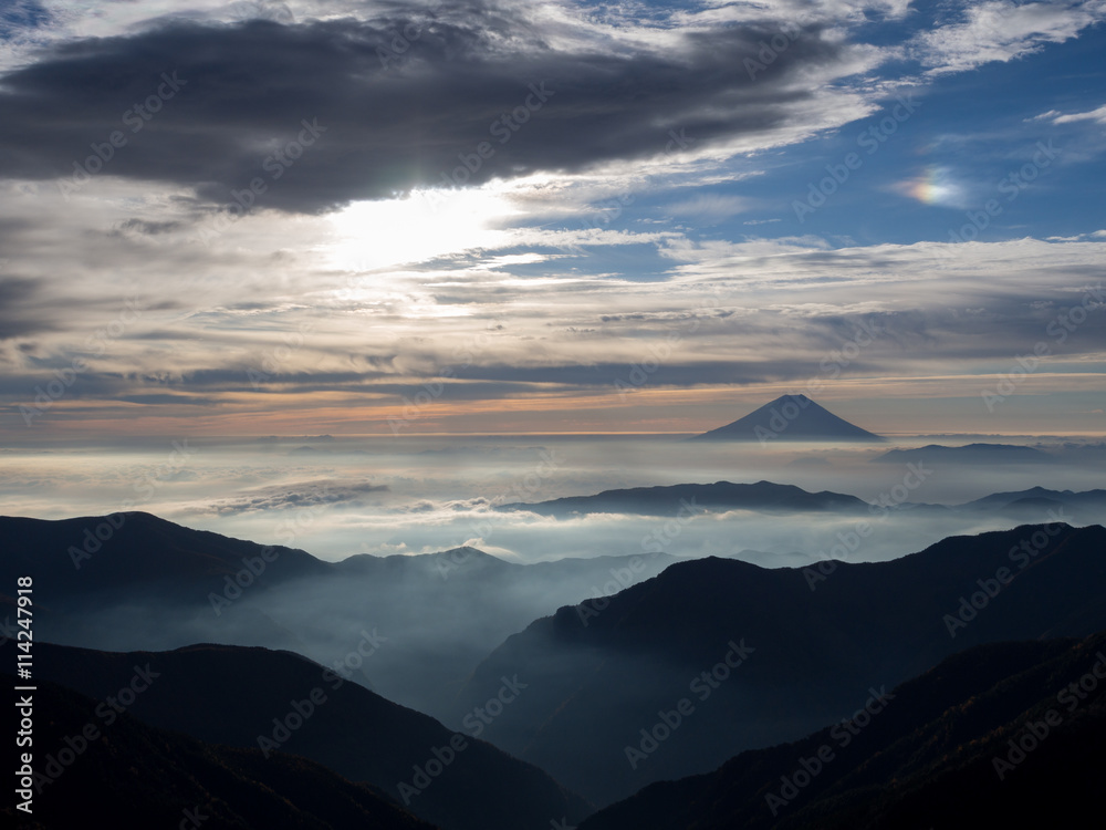Mt. Fuji over the mist with the overcast sky after sunrise in the morning, captured from Kitadake, Minami South Alps, Yamanashi Prefecture, Japan