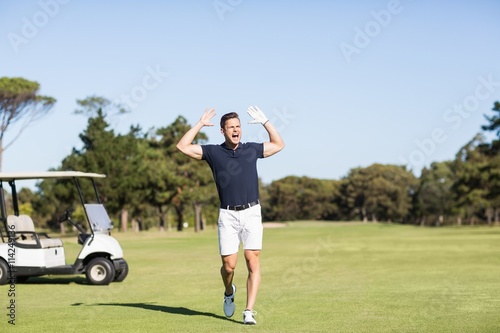 Golfer with arms raised while shouting