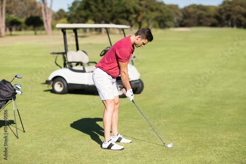 Side view of young man playing golf 