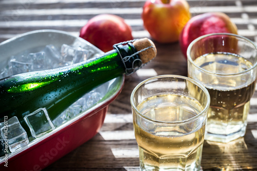 Photo Bottle and two glasses of cider on the wooden background