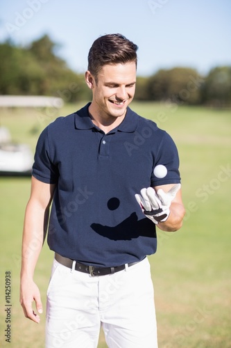 Cheerful young man with golf ball 