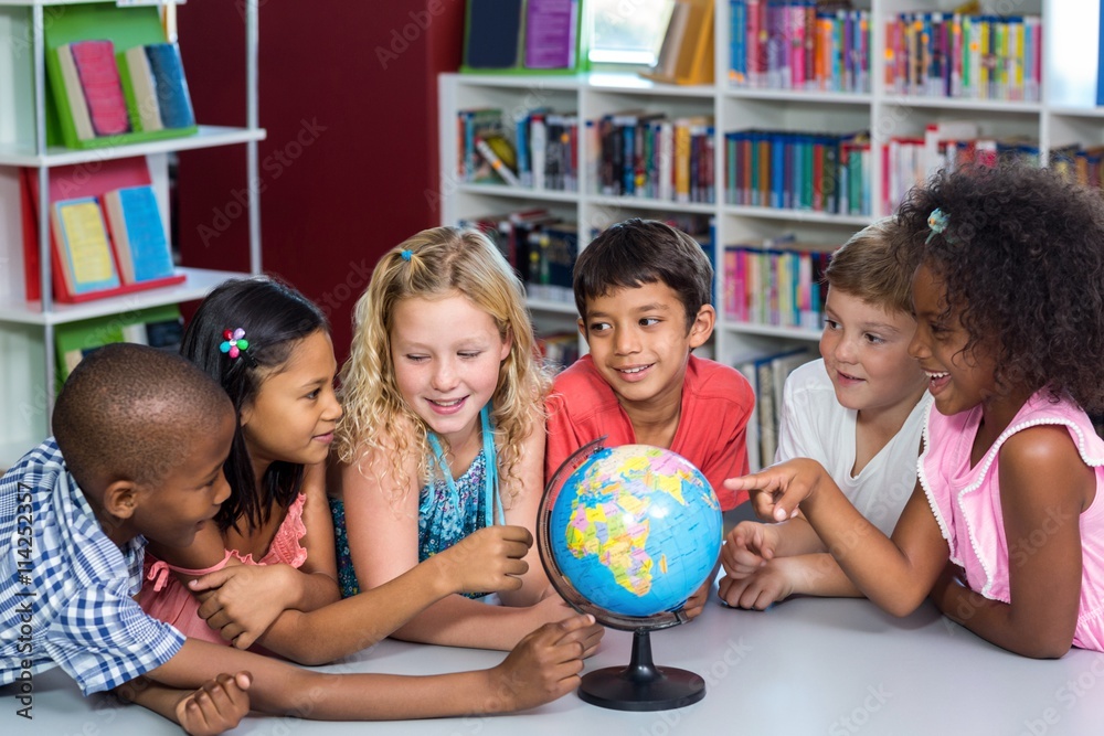 Fototapeta premium Children with globe on table