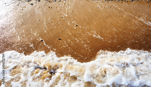 Sea wave on orange pebble sand beach © FenrisWolf