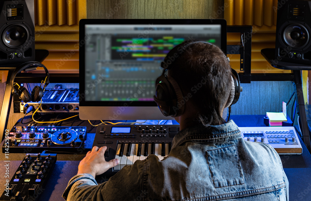 Fototapeta premium Jeden człowiek produkuje muzykę elektroniczną w domowym studio projektu.
