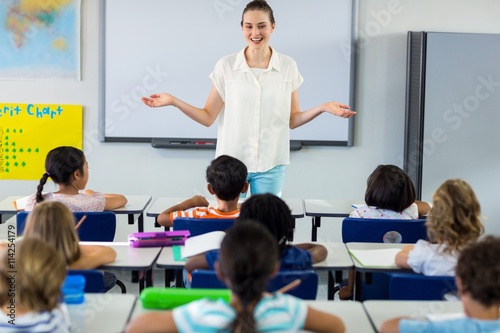 Teacher with arms outstretched in classroom