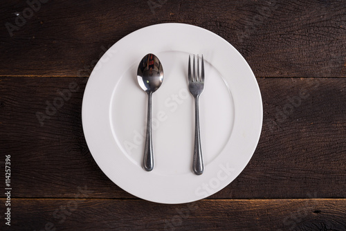 Empty plate dish and spoon and fork. Top view