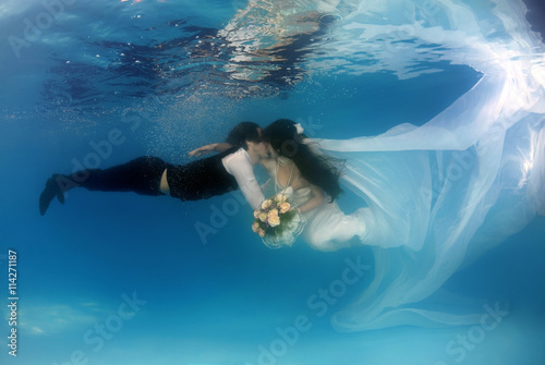 Bride and groom, underwater wedding in a pool photo