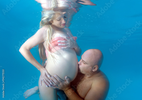 Pregnant woman and man in the pool photo