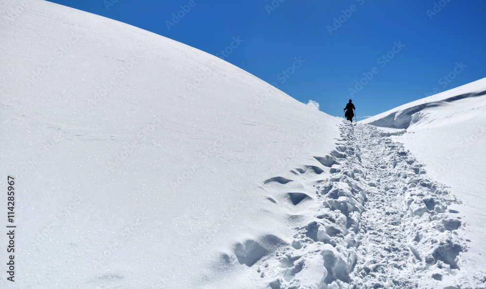 chemin dans la neige tracé par un  randonneur en montagne