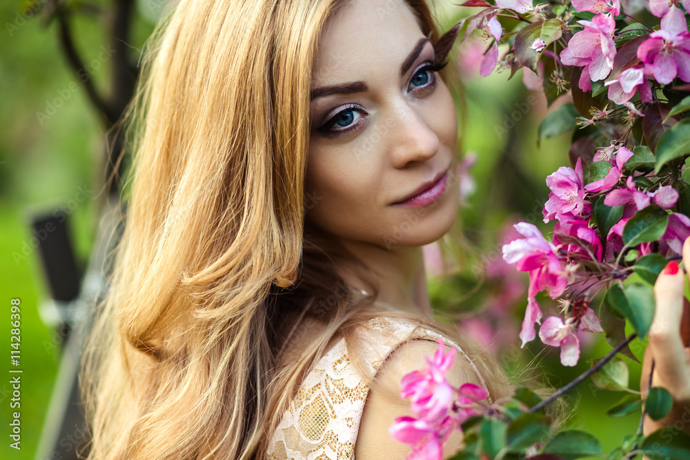 beautiful young woman in a summer dress near blooming trees beautiful young woman in a summer dress near blooming trees