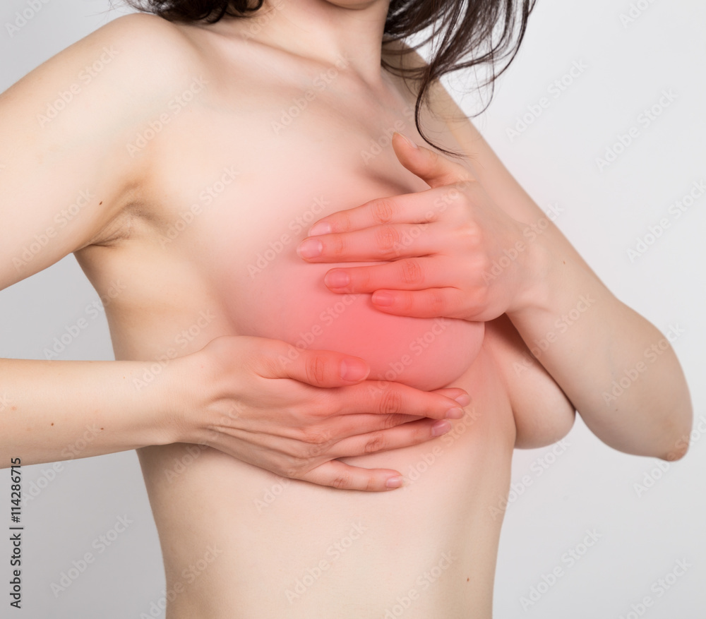 Breast cancer self check. Young woman examining her breast for lumps or signs of breast cancer. healthy lifestyle concept Breast cancer self check. Young woman examining her breast for lumps or signs of breast cancer. healthy lifestyle concept