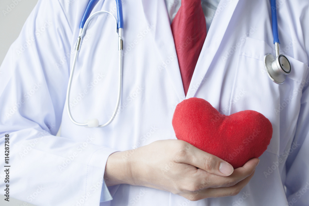 Doctor showing compassion and support holding red heart onto his Doctor showing compassion and support holding red heart onto his