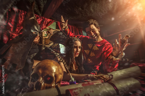 Medieval inquisitor is tempting witch to sign the confession, bu