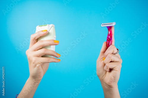 Red shaver and epilator in woman hands