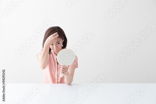 手鏡を見るミドル女性・白バック photo