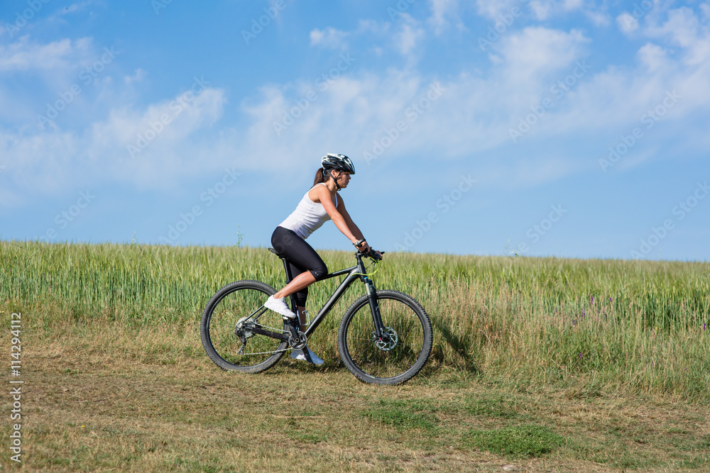 Happy Young Woman riding bicycle outside