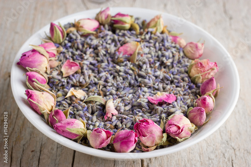 White bowl with pink dried roses and lavender flavers photo