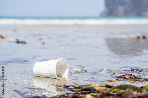 White plastic cup on the beach