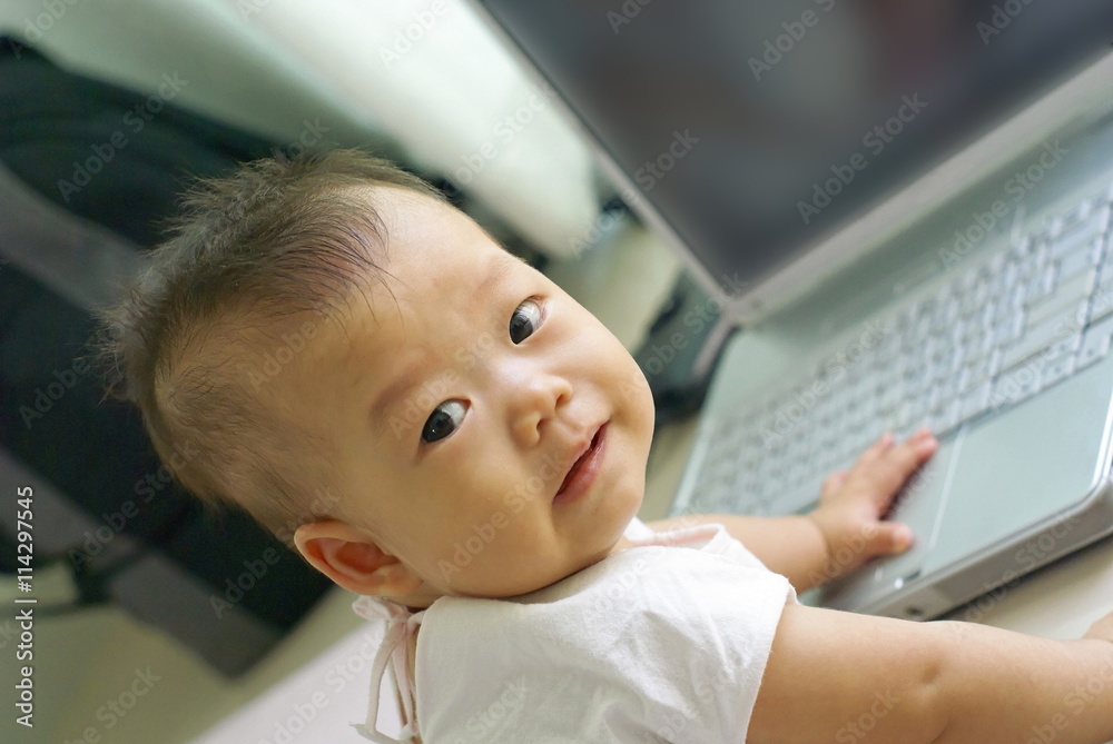 Asian infant is smiling on the floor with laptop computer. Asian infant is smiling on the floor with laptop computer.