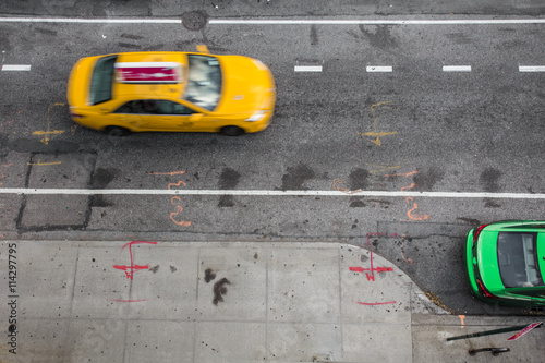 View of from above of urban street in New York City Manhattan with yellow taxi cab and car 