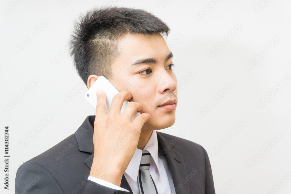 Handsome business asian man in black suit speaking on the phone Handsome business asian man in black suit speaking on the phone