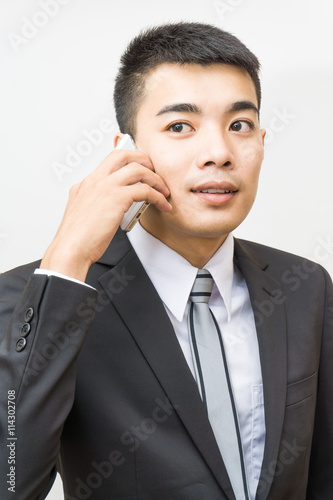 Handsome business asian man in black suit speaking on the phone