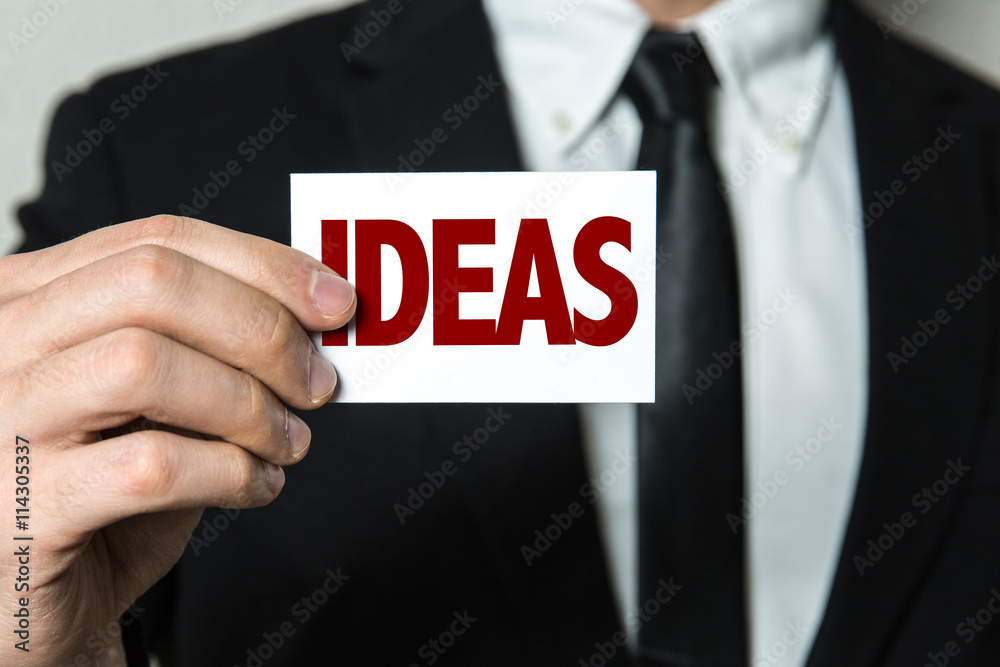 Business man holding a card with the text: Ideas Business man holding a card with the text: Ideas