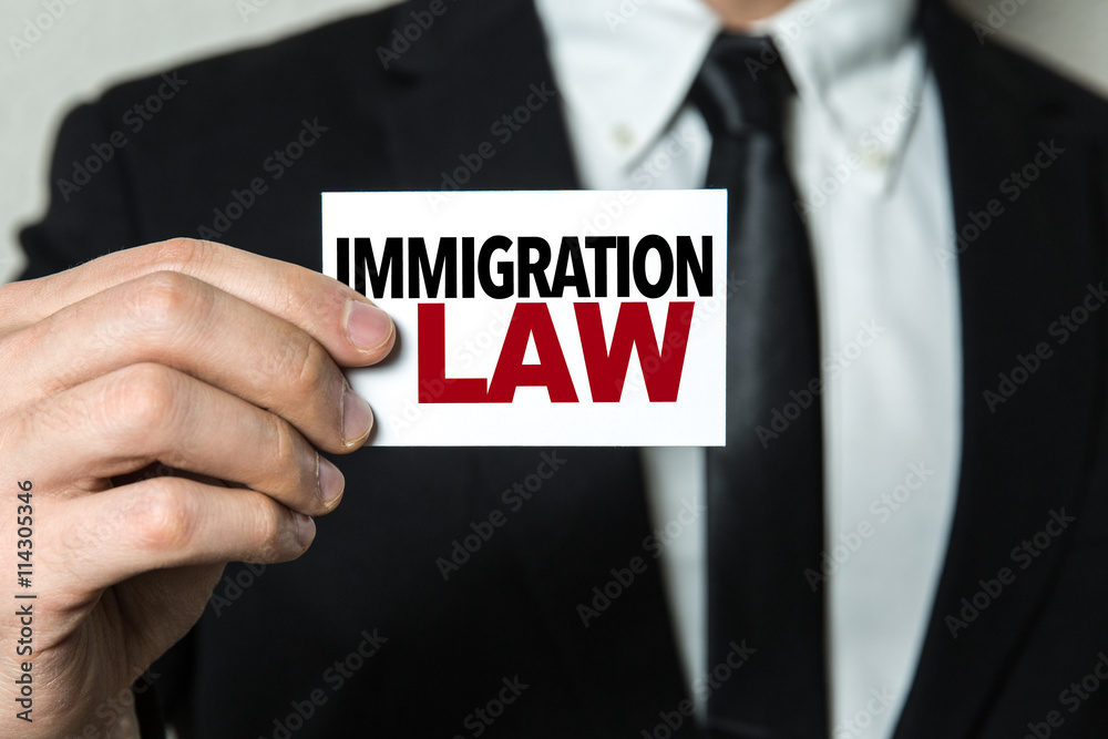 Business man holding a card with the text: Immigration Law Business man holding a card with the text: Immigration Law