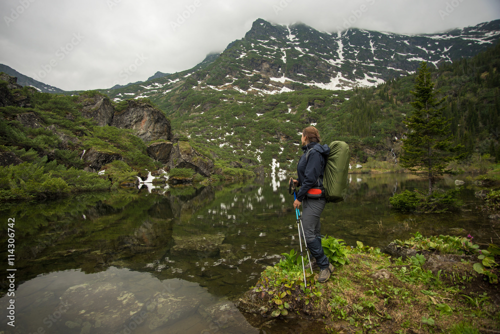 girl with backpack enjoying the view of a beautiful lake girl with backpack enjoying the view of a beautiful lake