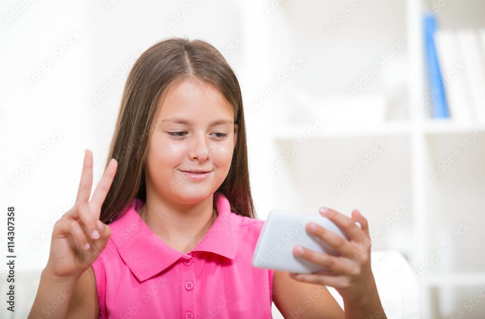 Smiling deaf girl talking using sign language on the smartphone' Smiling deaf girl talking using sign language on the smartphone'