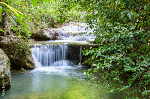Fototapeta Naklejka Na Ścianę i Meble -  Beautiful waterfall and tropical forests at Erawan National Park is a famous tourist attraction in Kanchanaburi Province, Thailand