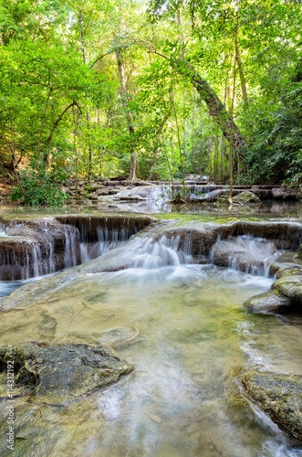 Fototapeta Naklejka Na Ścianę i Meble -  Erawan Beautiful waterfall and tropical forests at Erawan National Park is a famous tourist attraction in Kanchanaburi Province, Thailand in Thailand