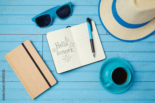 Summer holiday background with notebook for sketching and coffee cup. Vacation planning concept. Top view photo