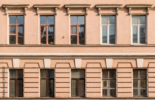 Several windows in a row on facade of urban apartment building front view, St. Petersburg, Russia.