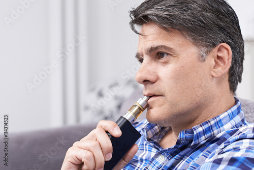 Mature Man Using Vapourizer As Smoking Alternative