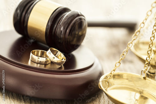 Divorce concept with gavel and wedding rings photo