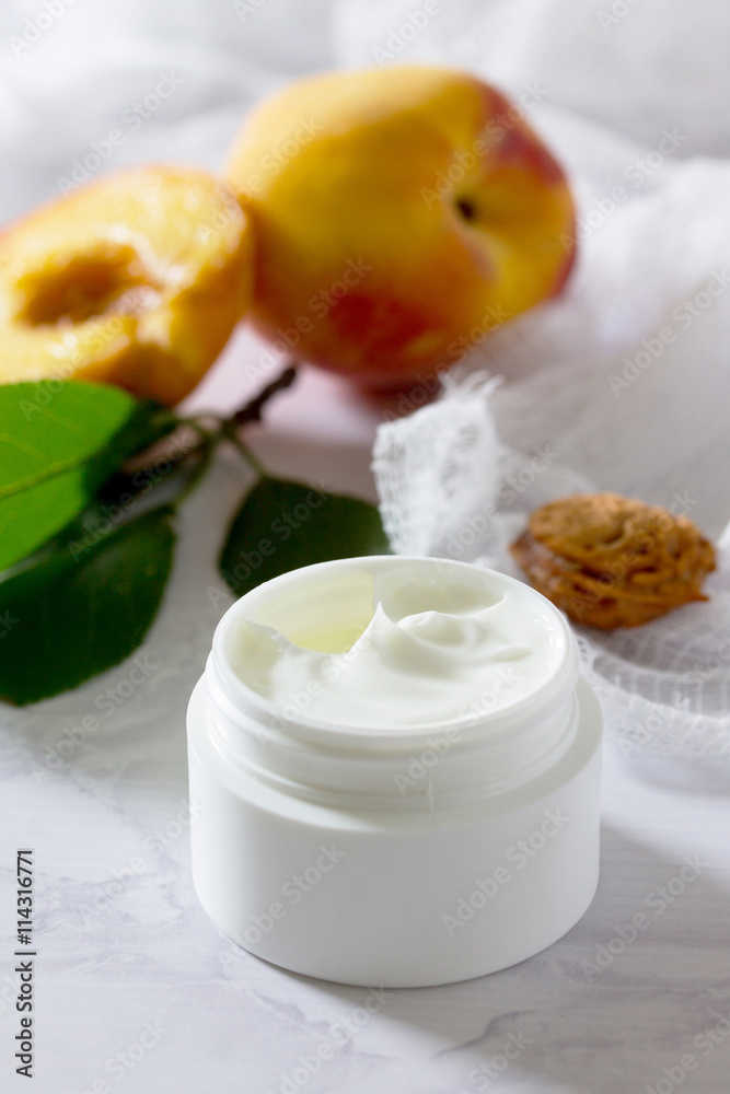 Face cream with peach on a gray stone background - beauty salon. Face cream with peach on a gray stone background - beauty salon.
